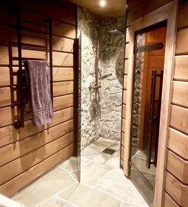 uma casa de banho com um chuveiro e uma toalha pendurada numa parede em Varglyan - Idre em Idre