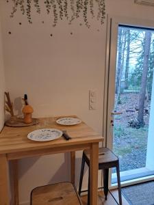een houten tafel met twee platen erop bij Chambre indépendante en forêt in Plessé