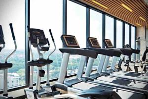 un gimnasio con varias cintas de correr en un edificio con ventanas en Astra Sky River Luxury 1B1BCondo, en Chiang Mai