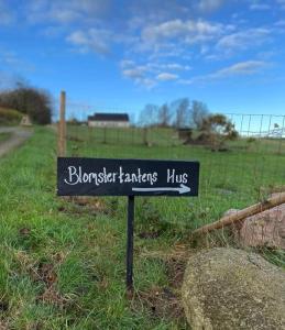 een bord voor brunswick boeren hutten in een veld bij Blomstertantens Hus in Trelleborg