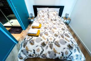 a bedroom with a bed with a comforter and pillows at Modern Loft at the heart of life in Avignon
