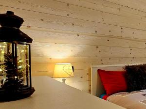 una lámpara sentada en una mesa junto a una cama en "Rouet" Bilocale a 15 minuti da Aosta VDA-Nus -CIR 0015, en Nus