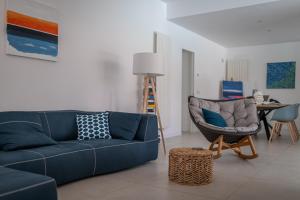 sala de estar con sofá azul y silla en Residence Corallo Portorosa Furnari, en Furnari