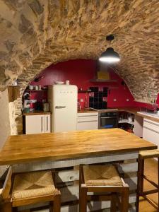 Saint-Jean-de-Fosにあるcharmante cave voûtée 4 personnesのキッチン(木製テーブル、冷蔵庫付)