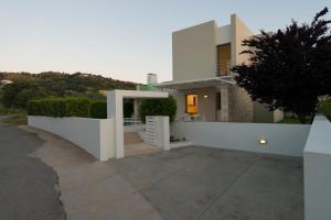 a white house with a white fence and a driveway at Villa Gonia in Gonia