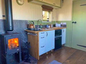 a kitchen with a stove and a stove top oven at Spring Grounds Farm Shepherd Huts 