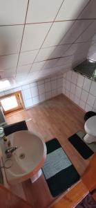 uma casa de banho com um lavatório e um quarto com em Cabana Kristof Kulcsosház em Borzont