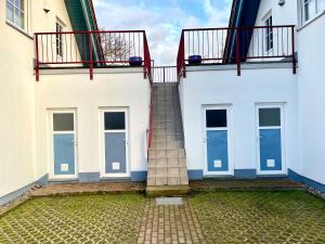 uma escada entre dois edifícios brancos com janelas em Ferienhäuser Liethmann Haus 4 W1 em Timmendorf