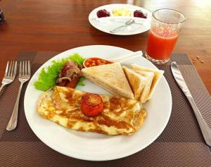 un plato de desayuno con huevos y tostadas y un vaso de zumo en Sri Lanka villa DSR , Wennappuwa, en Wennappuwa