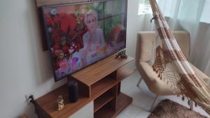 un soggiorno con TV a schermo piatto e sedia di Apartamento Único! a Conde