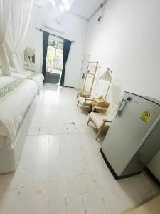 a large white room with a bed and a table at SYRI Boutique Guesthouse Restaurant & Cafe in Vientiane