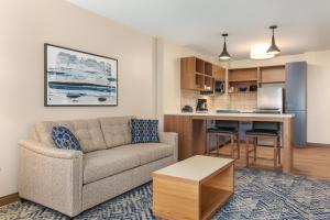 a living room with a couch and a kitchen at Candlewood Suites Collingwood, an IHG Hotel in Collingwood