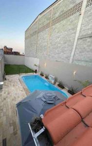 - une piscine avec un parasol dans un bâtiment dans l'établissement Casa Recanto dos Pássaros, à Marechal Deodoro