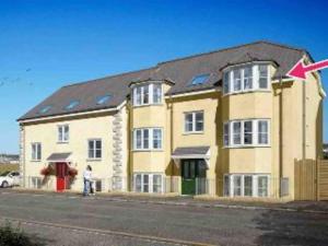 Un gran edificio amarillo con una flecha roja sobre él. en 4 Porth Gwel, Sea View & Parking, en Falmouth