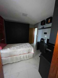 - une chambre avec un lit, un bureau et une télévision dans l'établissement Casa Recanto dos Pássaros, à Marechal Deodoro
