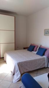 een slaapkamer met 2 bedden met blauwe en paarse kussens bij Porto Cesareo - Appartamento località Torre Lapillo - Orione C10 in Torre Lapillo