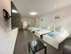 a living room with three beds and a table at Ring Home Stay in Adenau