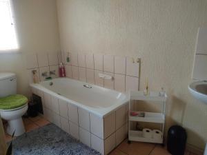 a bathroom with a tub and a toilet and a sink at Neatly Furnished Apartment in Mataffin