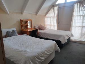 a bedroom with two beds and a desk and a window at Neatly Furnished Apartment in Mataffin