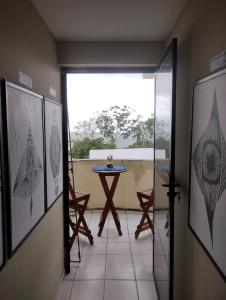 een kamer met een tafel en uitzicht op een balkon bij Pousada Claiô Suíte Estivas in Garanhuns