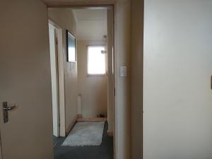 an empty hallway with a door and a window at Neatly Furnished Apartment in Mataffin