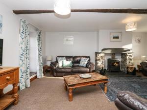 a living room with a couch and a fireplace at Cherry Tree Barn in Ulverston