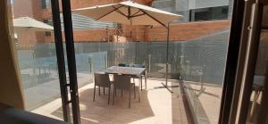 a table and chairs and an umbrella on a patio at Apartametos FACILE in Bogotá