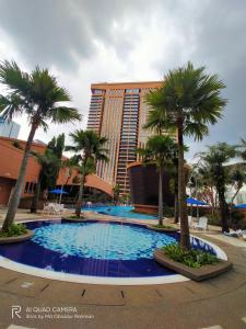 a large swimming pool with palm trees in front of a building at THE ROSEMARY SUITE At TIMES SQUARE in Kuala Lumpur