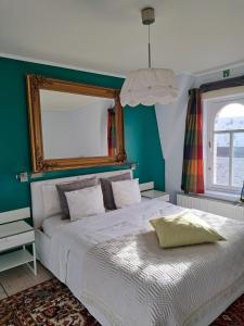 a bedroom with a white bed and a mirror at B&B Villa D'Hondt in Blankenberge