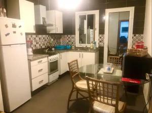 a kitchen with a table and chairs and a refrigerator at Superbe chambre dans un appartement à partager in El Aouina