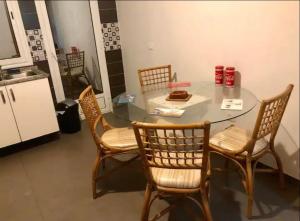 a table with four chairs and a table with a cake on it at Superbe chambre dans un appartement à partager in El Aouina