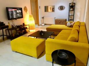 a living room with a yellow couch and tables at Superbe chambre dans un appartement à partager in El Aouina