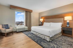 a hotel room with a bed and a chair and a window at Candlewood Suites Collingwood, an IHG Hotel in Collingwood