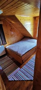 a bed in a sauna with a wooden ceiling at Cabana Kristof Kulcsosház in Borzont