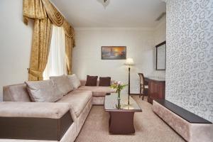 - un salon avec un canapé et une table dans l'établissement Royal Street Hotel, à Odessa