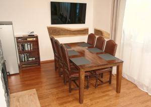 a dining room table with chairs and a television at Panskiemisie Domki Całoroczne sauna jacuzzi in Wetlina