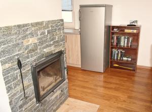 a living room with a stone fireplace and a book shelf at Panskiemisie Domki Całoroczne sauna jacuzzi in Wetlina