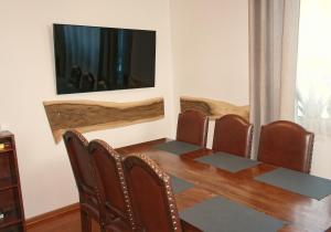 a dining room table with chairs and a flat screen tv at Panskiemisie Domki Całoroczne sauna jacuzzi in Wetlina +35 photos