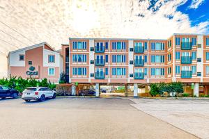 ein großes Apartmenthaus mit Autos auf einem Parkplatz in der Unterkunft Town of Dewey Beach -- The Opal #306S in Dewey Beach