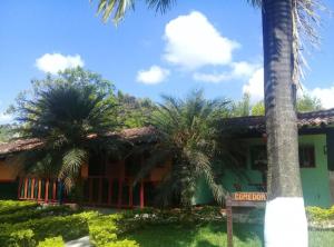 a house with two palm trees in front of it at Alojamiento rural finca estrella del Quindío in Montenegro