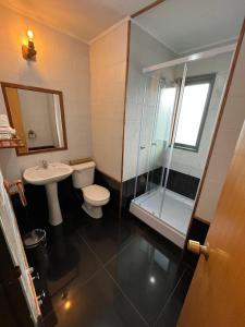 a bathroom with a toilet and a shower and a sink at Hotel Sueños del Volcan in Villarrica