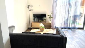 a living room with a black couch and a table at Superbe appartement classé 4 étoiles - le Boulou in Le Boulou