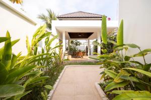 una pasarela que conduce a una casa con plantas en Ream YoHo Resort en Sihanoukville