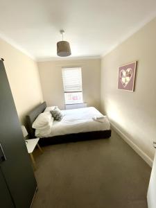 a small bedroom with a bed and a window at Bedford town house in Bedford