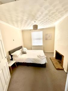 a white bedroom with a bed and a fireplace at Bedford town house in Bedford