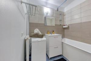 a white bathroom with a sink and a bath tub at Réconfort - 15 min de Paris in Saint-Denis