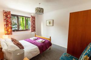 a bedroom with a bed and a window at UNDERWOOD COTTAGE - Peaceful House in Kendal with views of Cumbria in Kendal