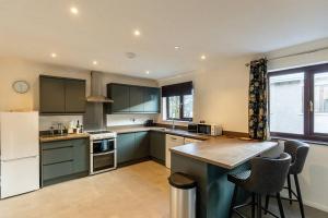 a kitchen with green cabinets and a counter top at UNDERWOOD COTTAGE - Peaceful House in Kendal with views of Cumbria in Kendal