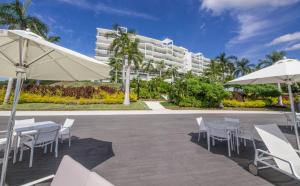 un patio con mesas y sillas blancas y un edificio en Bolongo, Punta de Mita Nayarit, en Higuera Blanca
