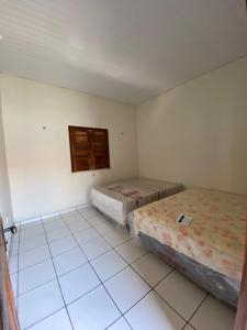 2 camas num quarto com piso em azulejo em Casa Temporada em Parnaíba